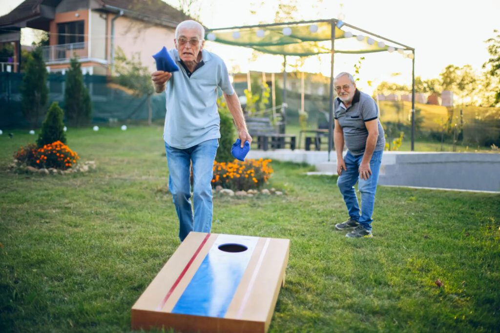 Backyard deck with cornhole setup by Trinity Fence & Deck Two men playing cornhole on a custom backyard deck built by Trinity Fence & Deck in Austin, Texas