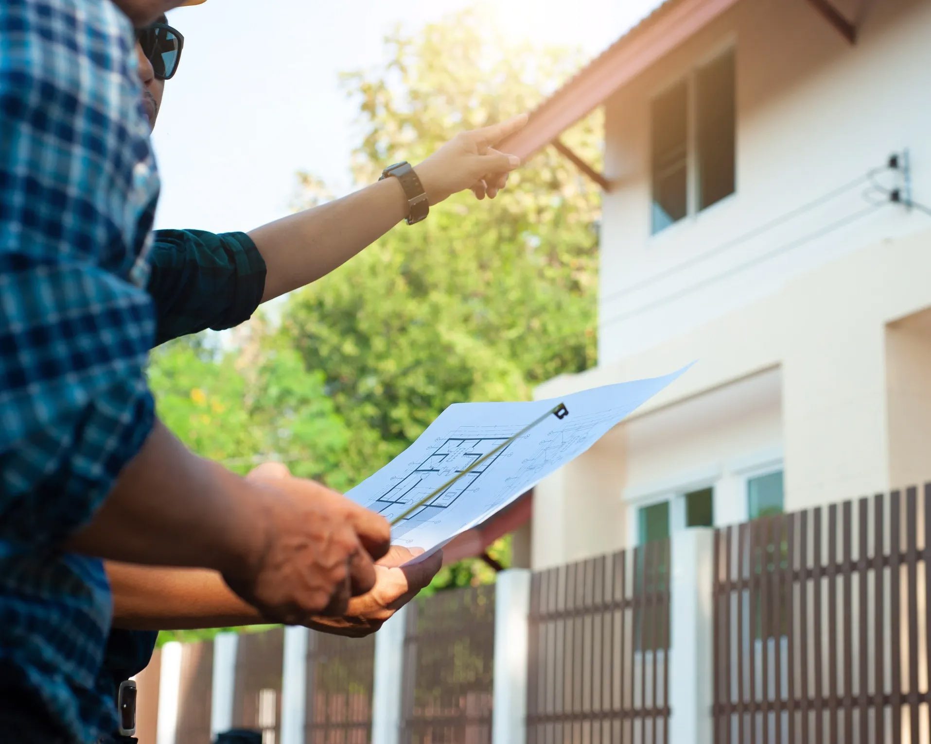 Contractor reviewing plans in front of partially built home