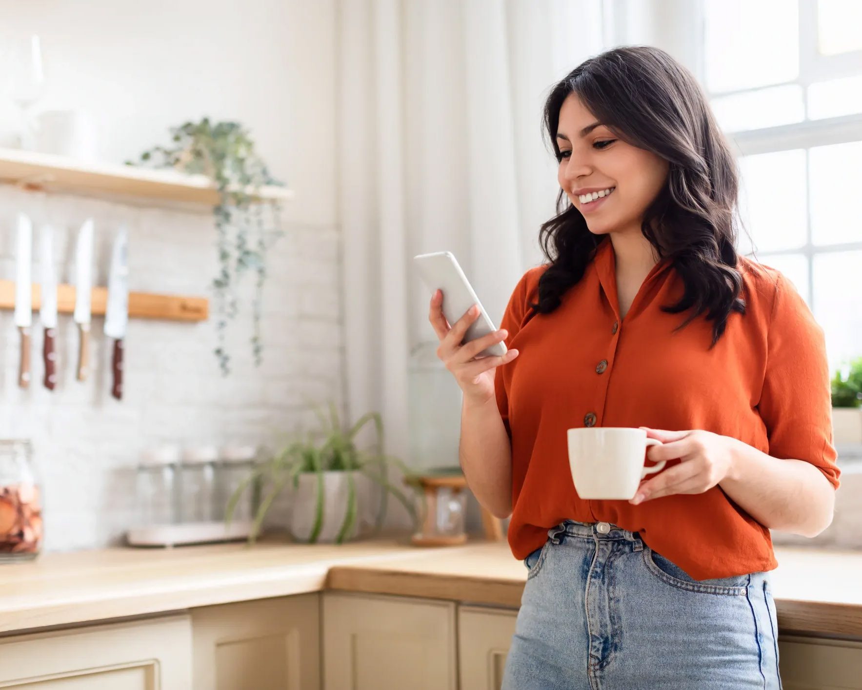 Homeowner smiling in bright kitchen with coffee cup