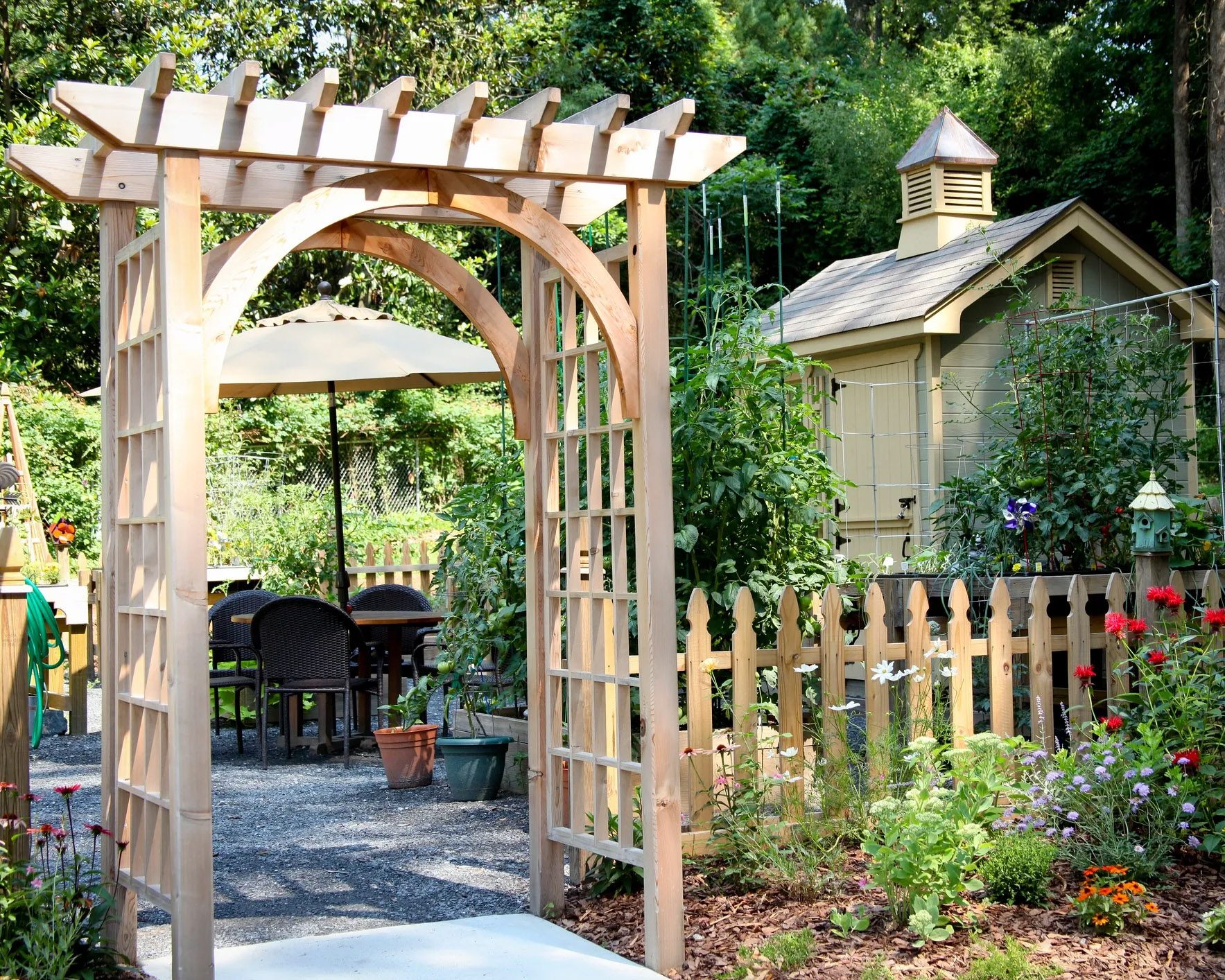 Open-top pergola with wooden beams overlooking scenic backyard