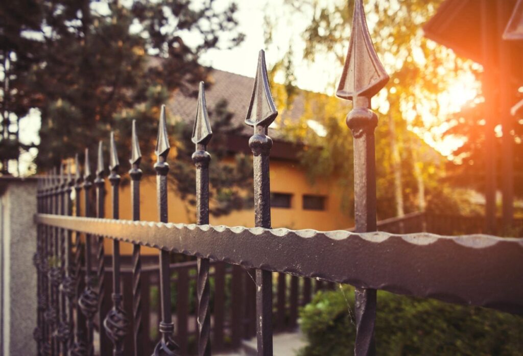 ornamental iron fence surrounding traditional home