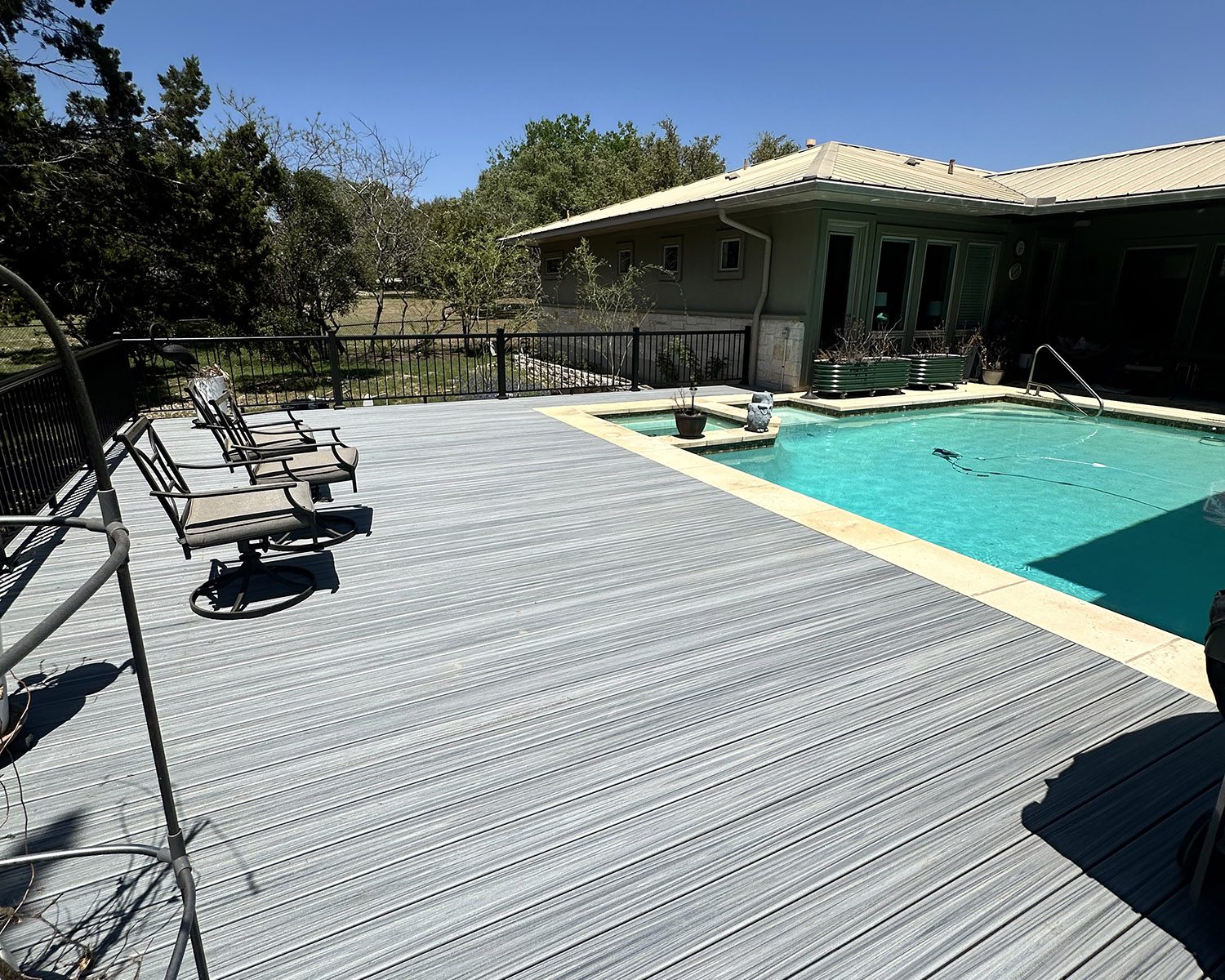 Composite deck with iron railing next to a private pool