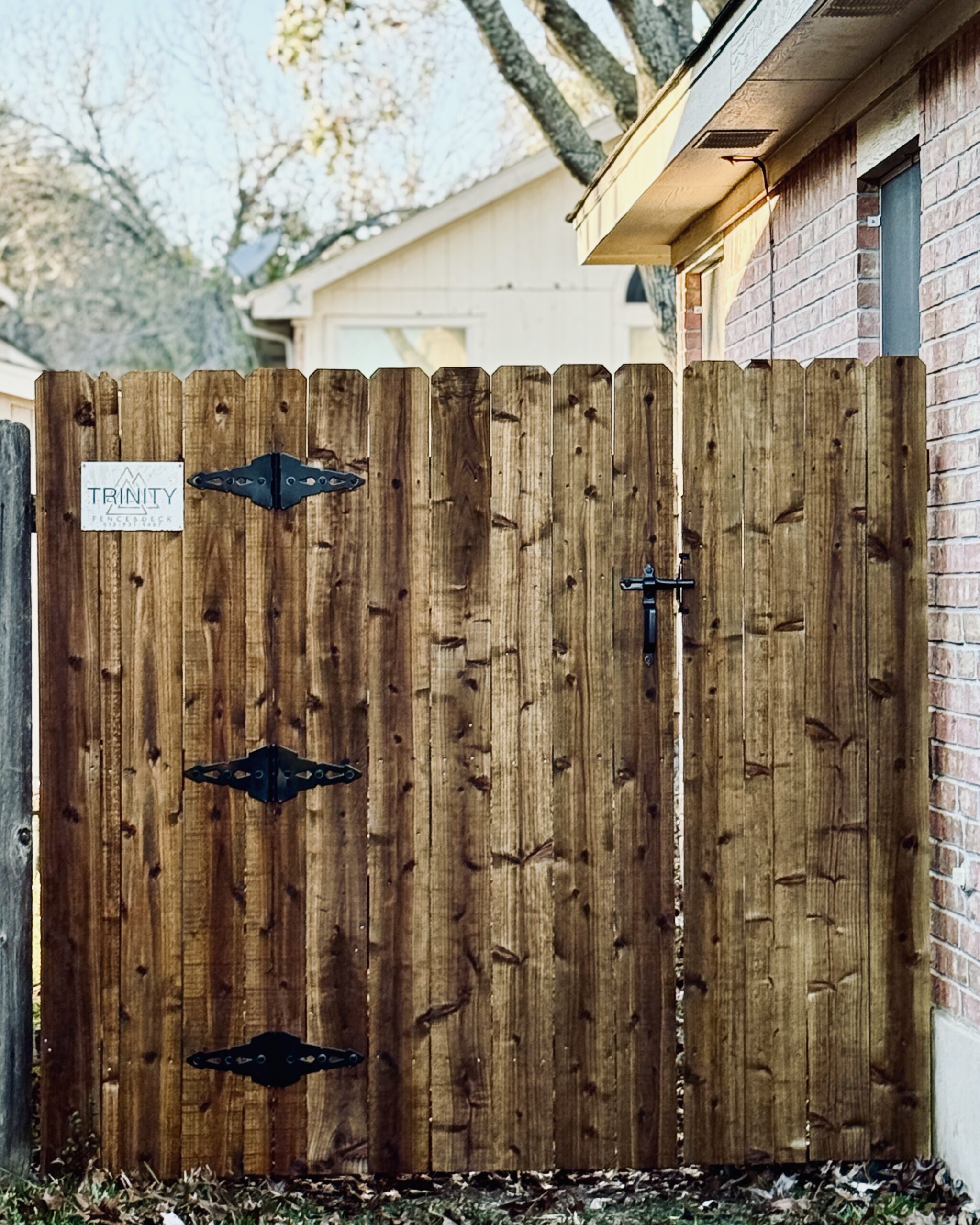 Stained wooden fence gate with rich brown finish highlighting wood grain and craftsmanship